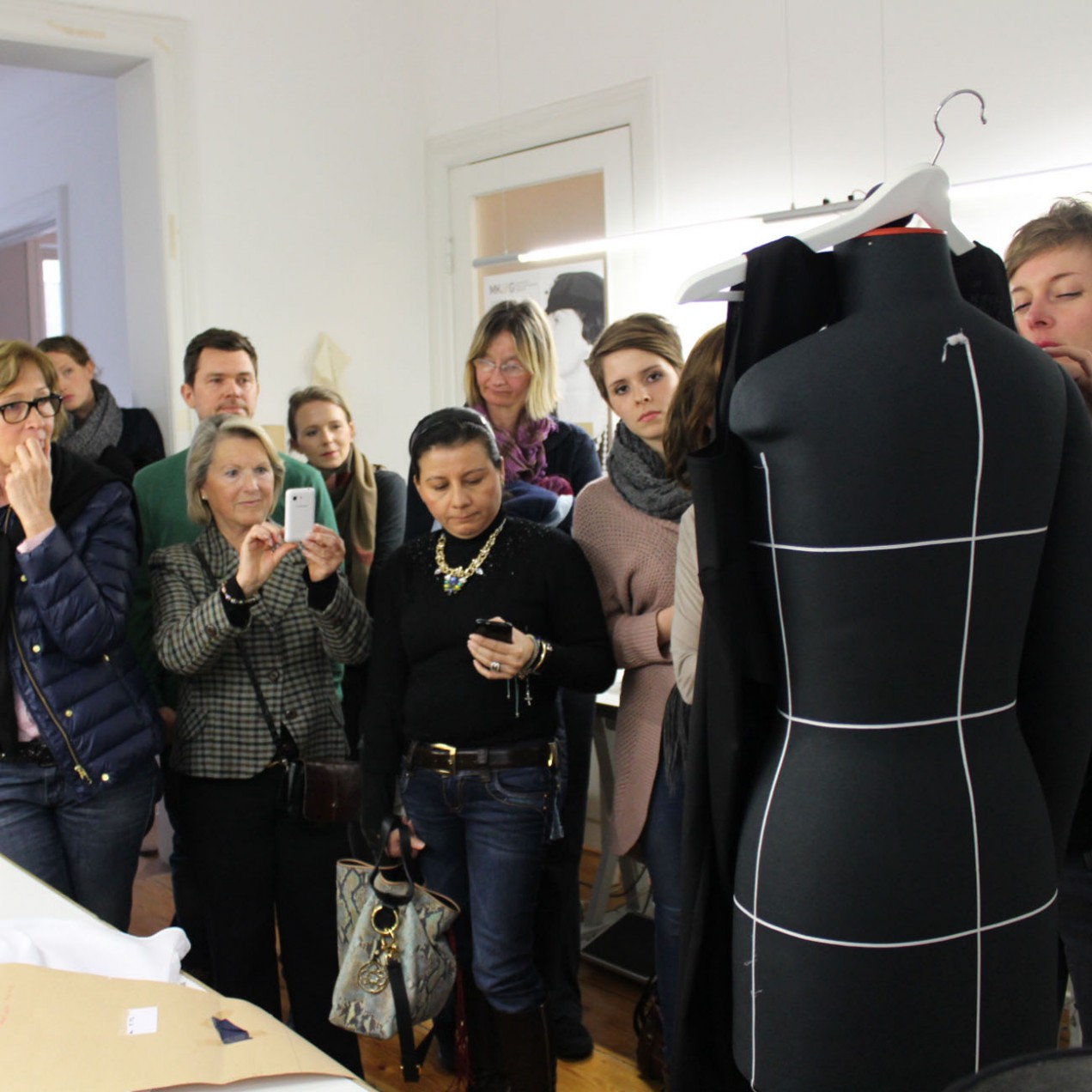 Als Irina an der Puppe die einzelnen Teile eines Kleidungsstück zeigt, sind alle besonders aufmerksam; Foto: MKG